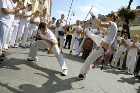 Uliczny pokaz capoeira w wykonaniu grupy FICAG z wykorzystaniem tradycyjnych instrumentów - bębnów, berimbau, caxixi, pandeiro