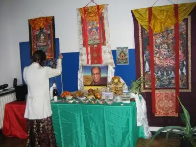 Tybetanka składa życzenie przed ołtarzem noworocznym wysypując Tsampe w górę w Warszawie